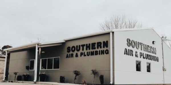 Modern commercial building with tan and white exterior displaying Southern Air & Plumbing signage on both sides.